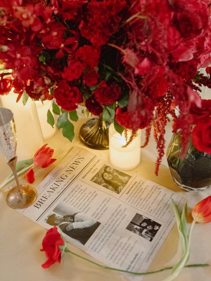 A custom-printed newspaper sharing the couple's story, used as a unique and personal element on the guest tables.