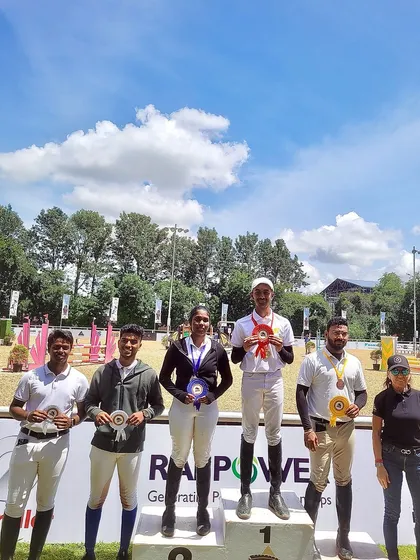A wider shot of the podium, with Nakshath celebrating his gold medal win. The joy of victory is shared by the whole team.