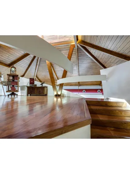 The mezzanine level, which serves as a more intimate exhibition area. The design of this space respects the geometry of the original roof structure while introducing a modern element.