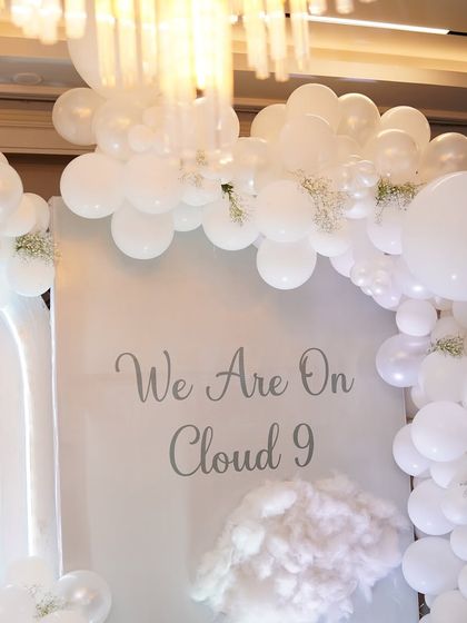 The 'We Are On Cloud 9' sign, surrounded by a cloud of white balloons and baby's breath. This simple yet elegant detail perfectly captures the feeling of expecting a new baby.