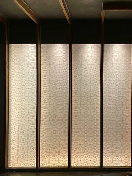A close-up, work-in-progress shot of the Chikankari-patterned light panels in the Lucknow penthouse, showing the detail of the craft before the final installation.