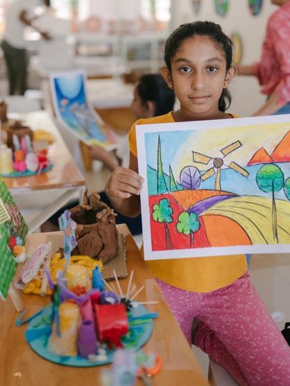 This young artist is holding up her colorful landscape painting, one of several pieces she created during our multi-day art camp. I focus on teaching techniques that empower kids to bring their own visions to life.