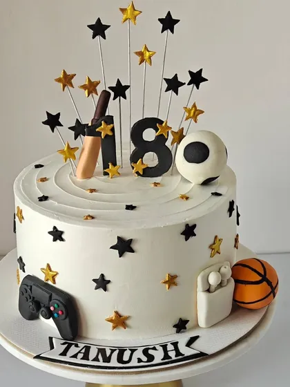 18 and ready to take on the world! This cake celebrates a young man's favorite things: cricket, football, gaming, and his AirPods, all represented with fondant toppers.