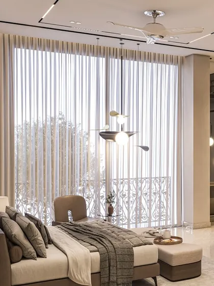 A detail shot of a bedroom, focusing on the chaise lounge and the view to the balcony. The sheer curtains diffuse natural light, creating a soft and calming ambiance.