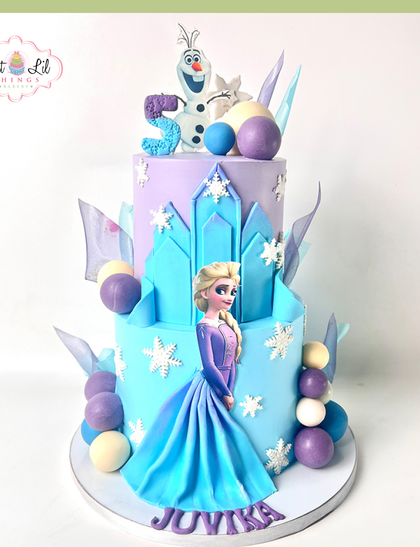 Let it go! This spectacular two-tiered Frozen cake brings the magic of Arendelle to life. It features Elsa, Olaf, and an icy castle, all decorated with shimmering snowflakes and cool blue and purple tones.