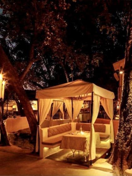 The restaurant at night, with candelabras and soft lighting creating a warm and inviting glow throughout the terrace.