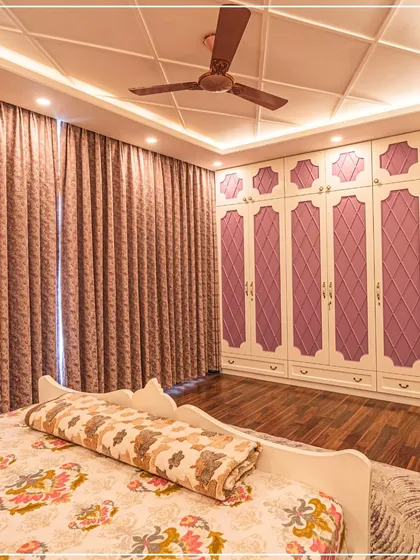 A bedroom with lavender-paneled wardrobes and a classic coffered ceiling, creating a soft, romantic feel.
