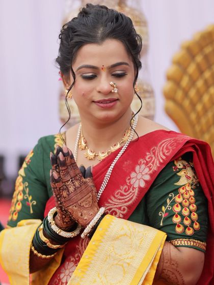 A moment of prayer during the wedding ceremony. The intricate mehendi stain on her hands is beautifully highlighted in this candid shot.