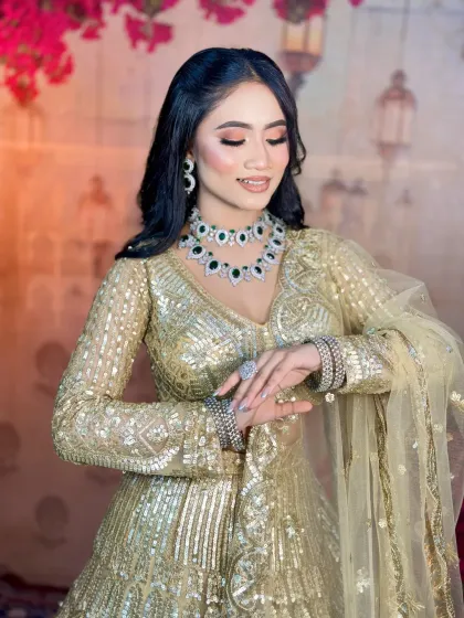 A candid shot of the model admiring her look. The soft waves in her hair and the sparkling jewelry complete this perfect engagement party style.
