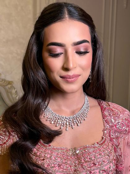 A close-up of the bride's soft makeup and her classic half-up hairstyle.