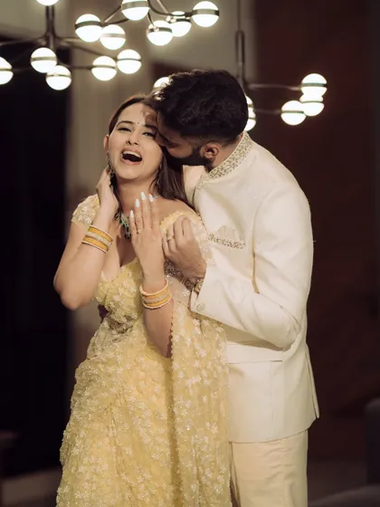 A joyful and candid shot from a Mumbai engagement shoot. The modern lighting and the couple's laughter create a vibrant and energetic image that perfectly captures the celebratory mood.