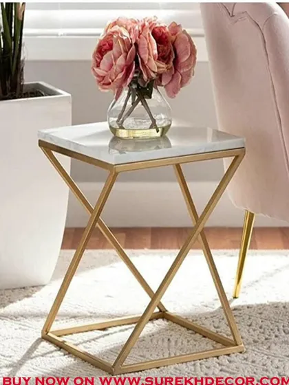 A chic and modern side table with a white marble top and a rigid, geometric golden base. This piece is perfect for adding a touch of glamour next to a sofa or armchair, providing a stylish surface for a lamp or decor.