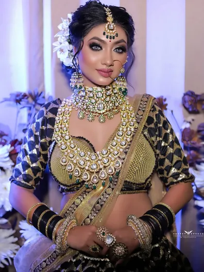 A full mid-shot of the bride in a striking black and gold lehenga, perfect for a sangeet or reception look.