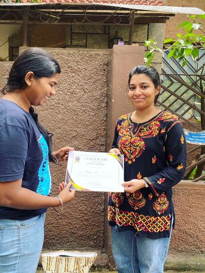 A student receives her certificate, a symbol of her dedication and new skills. It's a proud moment for everyone at Heels on Wheels.