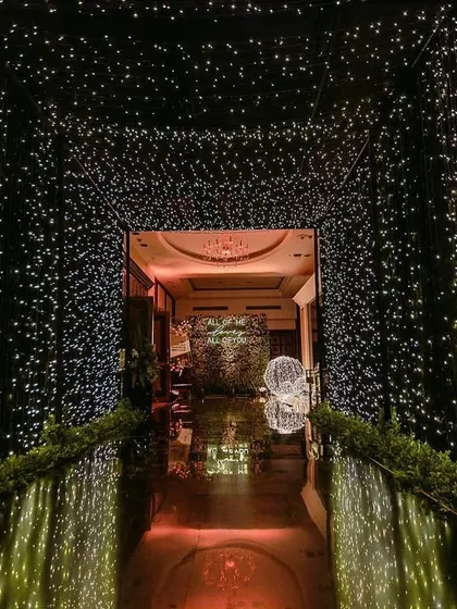 A magical entrance tunnel created with thousands of fairy lights, leading guests into the sangeet venue.