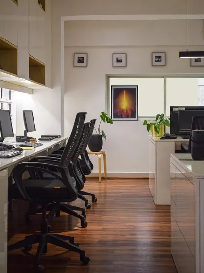 A look at a workstation cluster in my studio. The design prioritizes natural light and an uncluttered environment to foster focus and creativity. The warm wooden flooring provides a grounding element to the bright, modern space.