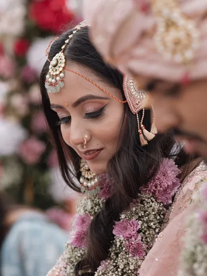 A tender moment during the wedding rituals, with the bride and groom sharing a quiet connection amidst the ceremony. The focus is on their expressions and the delicate details of their attire.