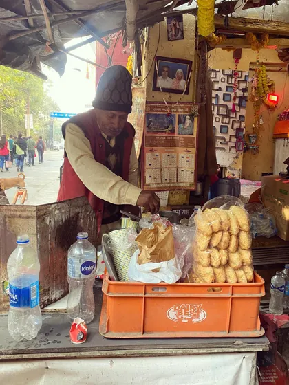 A street vendor serves up a local snack near the Yamuna Bazar. Our walks often include stops at lesser-known spots that offer a glimpse into the everyday life and flavors of the city.