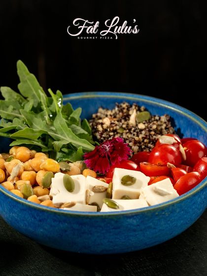 A healthy and hearty Protein Bowl, filled with quinoa, chickpeas, fresh vegetables, and feta cheese. It's a perfect choice for a light yet satisfying meal.