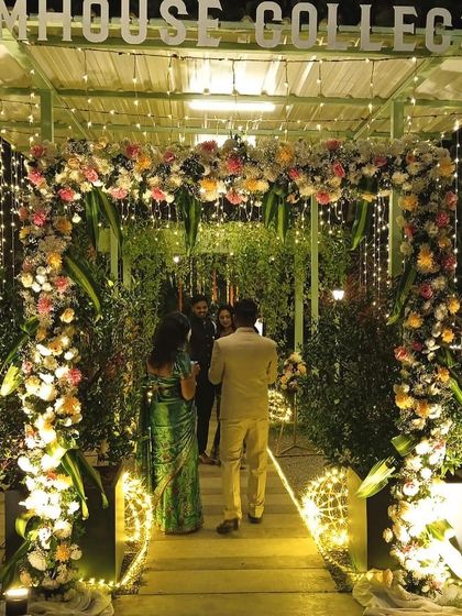 Another view of the enchanting floral entrance, lit up with fairy lights for an evening event.