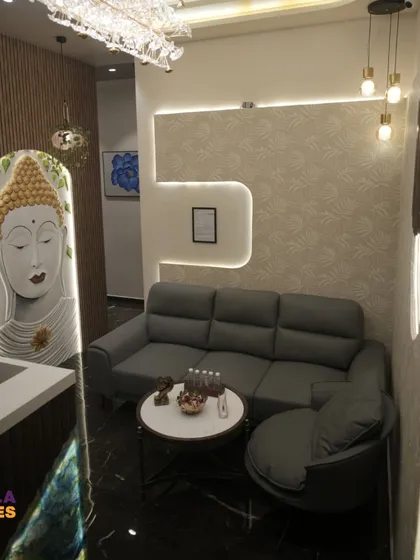The waiting lounge of the spa features a comfortable L-shaped sofa and a custom Buddha art installation. We used recessed and layered lighting to create a soft, inviting ambiance where guests can relax before their treatments.
