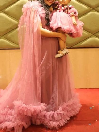 Our dusty pink mother-daughter combo features a gown with a removable cape and a matching baby frock. This versatile design gives you two looks in one for any birthday party.
