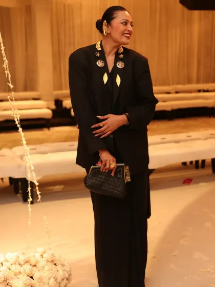 A candid moment at the Rohit Bal show. This look, featuring a saree styled with a power-shoulder blazer and bold gold accessories, is all about owning your space with confidence and high-fashion sensibility.