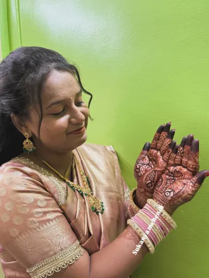 The bride admiring her intricate mehendi. This shot captures the personal connection clients have with their henna.