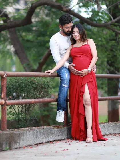 An outdoor maternity session offers a completely different vibe. We used the soft, natural light of a park in Navi Mumbai to capture this relaxed and romantic portrait. The vibrant red dress against the greenery creates a beautiful, timeless image.