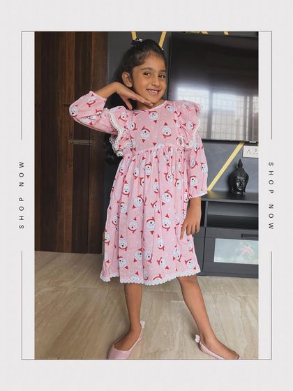 Dress your little angel in our pink cotton Christmas frock. The Santa print is adorable, and the white lace detailing and frill sleeves add an extra touch of sweetness.