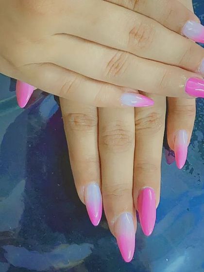 A striking pink and white ombre on long, pointed stiletto nails for a bold and dramatic gradient effect.