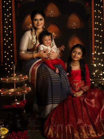 A beautiful family celebrating Diwali together. The warm light from the diyas creates a magical and intimate atmosphere.
