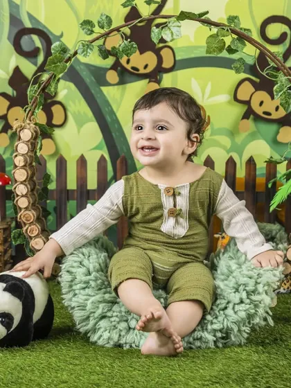 This little adventurer is enjoying his comfy seat in the middle of the jungle, surrounded by playful monkeys.
