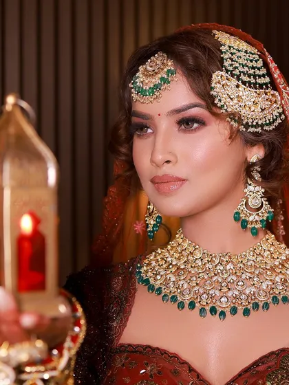 A beautifully composed shot of our royal bride. The warm lighting highlights the depth of her lehenga and the sparkle of her jewelry.