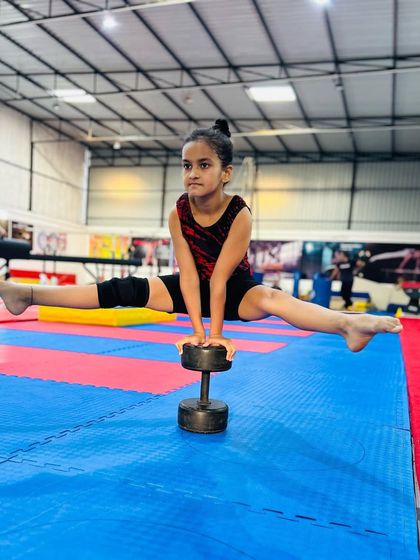 Strength and balance combined. This young gymnast holds a challenging split on a dumbbell, showcasing incredible core control and stability that we build through a variety of conditioning exercises.