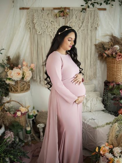 A serene and loving solo portrait. The mother-to-be looks down at her baby bump, her hands cradling it in a gesture of deep connection.
