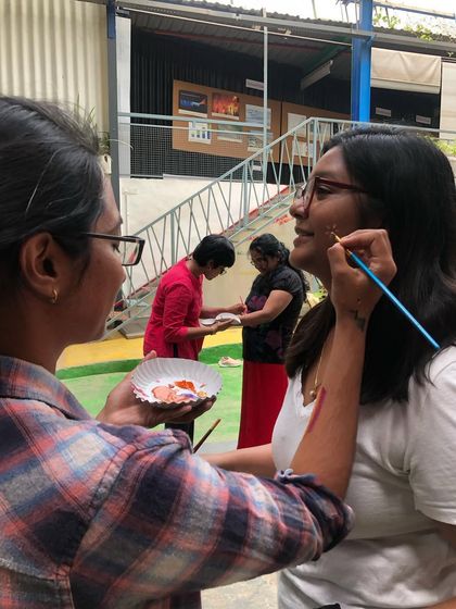 Participants painting on each other's faces and arms. It's all about playfulness and breaking down barriers.