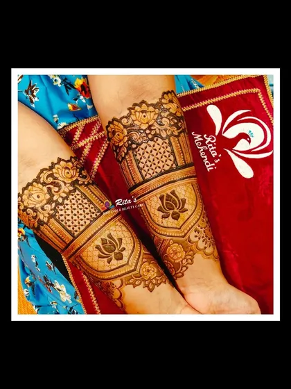 A close-up of the arm design, featuring bold lotus motifs inside elegant frames, combined with delicate net-like patterns.
