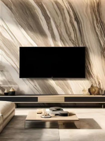 A dramatic living room design centered around a full-height, book-matched marble-effect wall. The minimalist floating console and natural wood shelving on the side provide balance and functional storage.