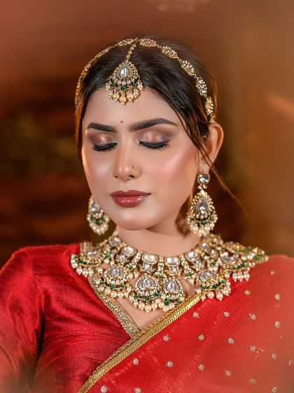 A close-up of a warm, bronzed bridal look with a beautiful red lehenga. The focus here is on the glowing skin and perfectly defined eyes, techniques we cover in-depth.