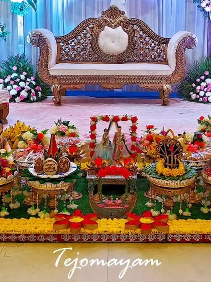 A traditional engagement plate decoration with a focus on symmetry. The setup features two chairs for the couple, with the plate arrangement in the center.