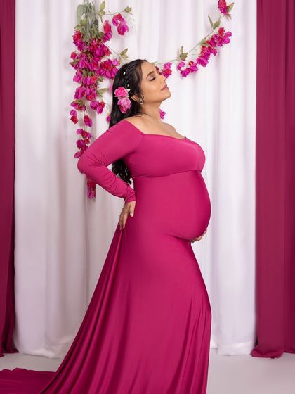 A powerful and proud pose, showcasing the baby bump in this stunning magenta gown.