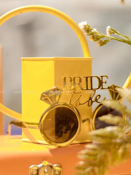 Fun "Bride to Be" props, including oversized golden glasses, ready for the bride tribe to use for photos.