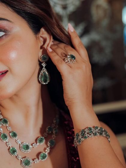 It is all in the details. This shot highlights the flawless makeup and how it complements the stunning emerald jewelry, adding a touch of luxury to this Sangeet look.
