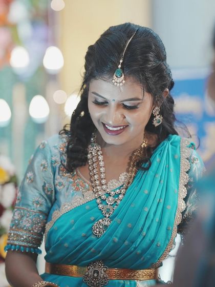 A close-up of Manasa's naming ceremony look. The turquoise saree is so vibrant, and the makeup complements it beautifully.