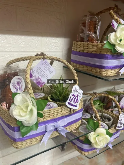 A collection of the elegant 70th birthday hampers, each featuring a Kauna jute basket, a ceramic planter, and other thoughtful gifts.