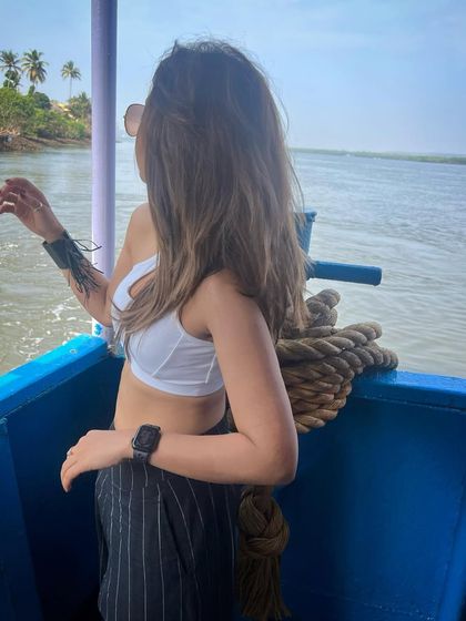 Enjoying a boat ride in Goa. A simple white crop top and pinstripe trousers make for an easy, breezy, and stylish holiday look.