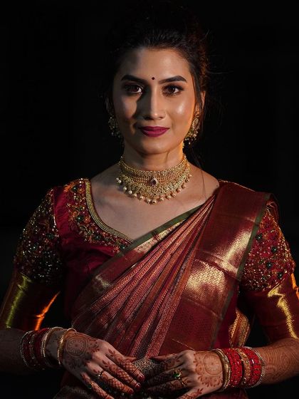 A dramatic portrait of Impana from her reception. The lighting beautifully captures the glowing finish of her skin and the rich color of her lipstick.