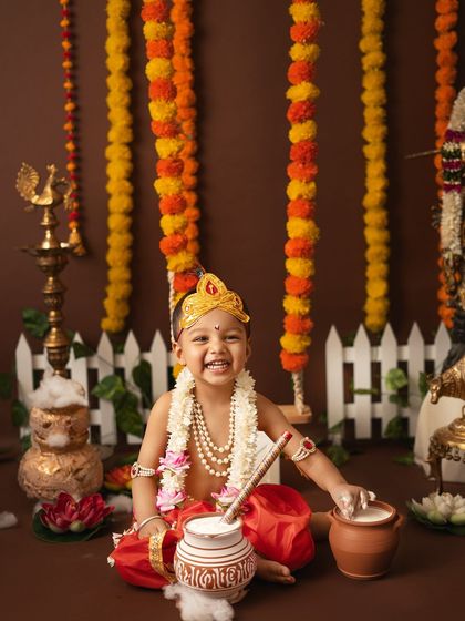 This little Krishna is having the best time with his pot of butter. The genuine, wide smile makes this photo an absolute treasure.
