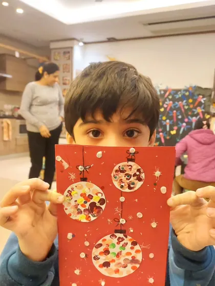 Christmas is in the air! A student from my adorable toddler group (3 to 6 years) proudly shows off the fingerprint ornament card he made.